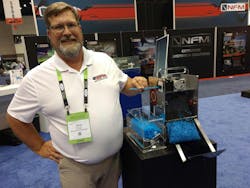 Bay Plastics Machinery President Jason Forgash shows off a system he devised for cutting and collecting straws for recycling.