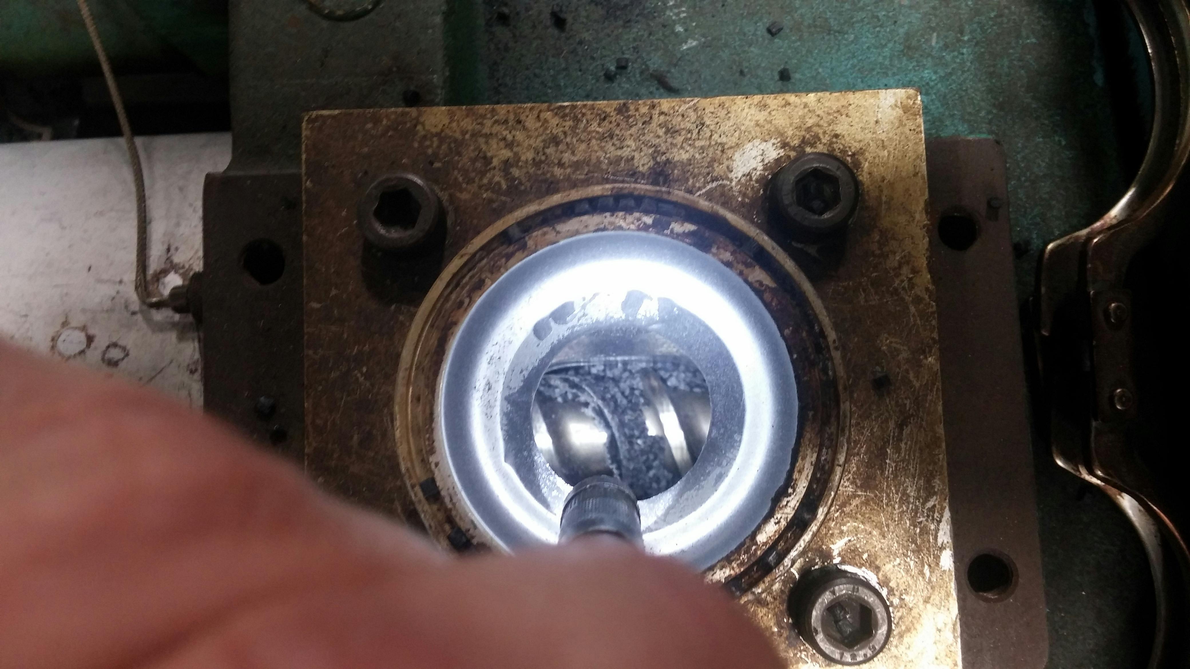 With good data monitoring practices, molders can not only optimize their processes but protect their equipment. Here, Umberto Catignani, the president of Orbital Plastics Consulting, looks down a feed throat of a machine, examining screw flights where plastic has melted and stuck due to bridging caused by excessive temperatures.