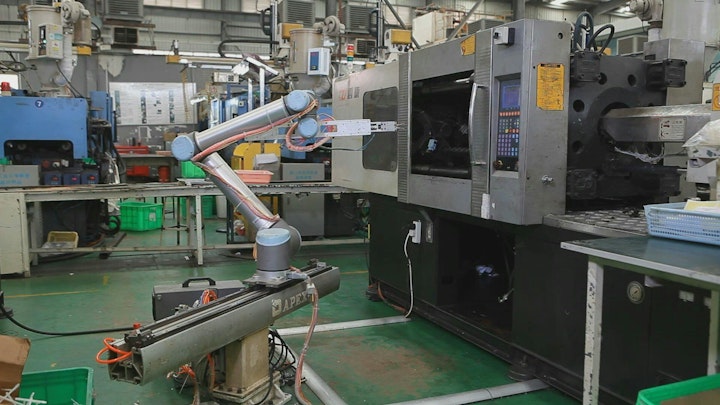 A Universal Robots cobot on a slider tends an injection molding machine at Xiamen Runner Industrial Corporation in China.