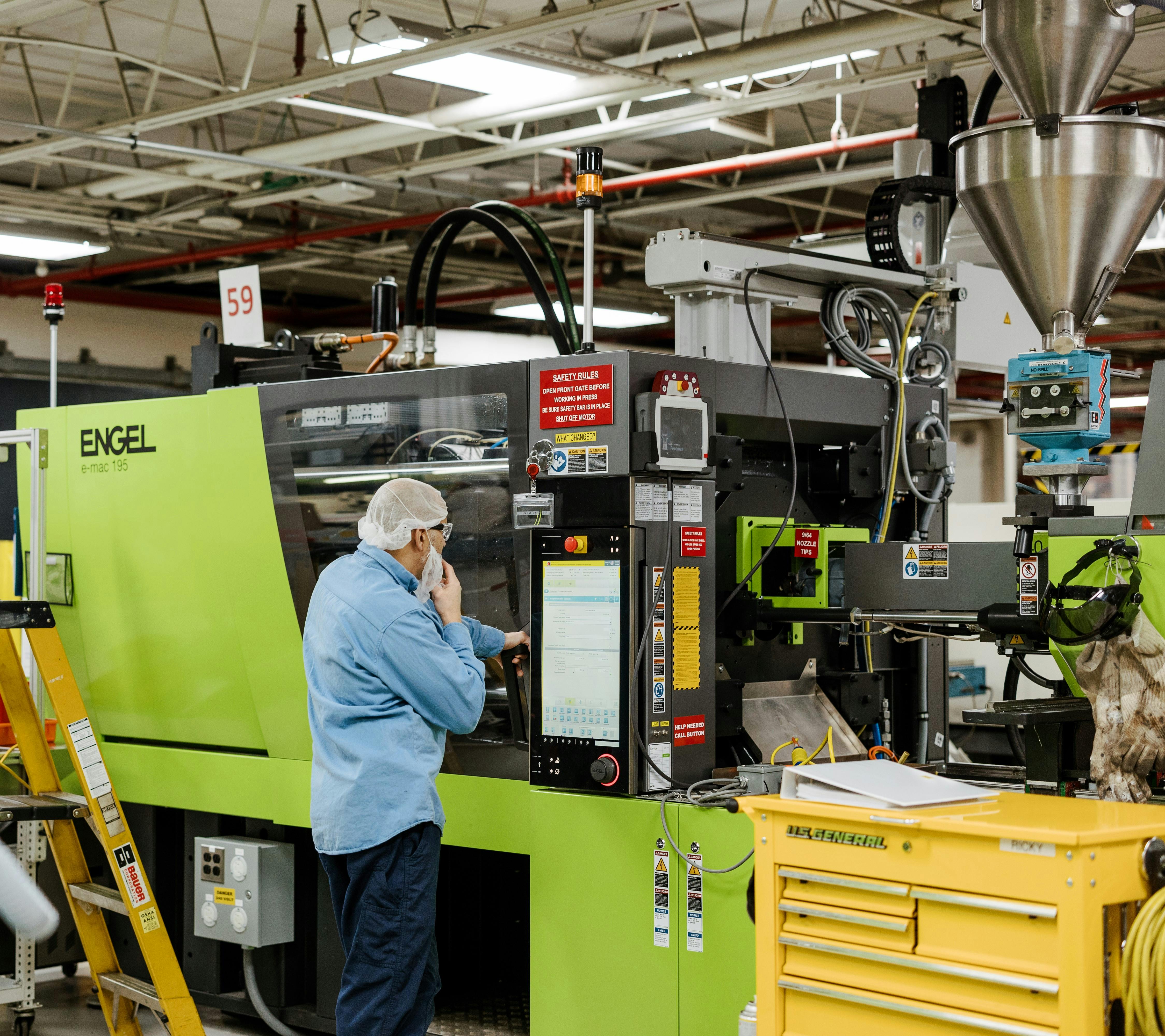 An employee at Hoffer Plastics works on an all-electric Engel e-mac 195 injection molding machine appropriate for making medical devices, electronics and packaging. When it comes to her employees, co-CEO Gretchen Hoffer Farb calls herself a 'mama bear'.