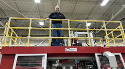 R&B Plastics Machinery President and GM Fred Piercy atop a blow molding machine at the company's Saline. Mich., plant.