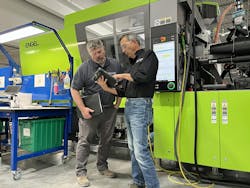 Members of Dynamic’s team work near an Engel injection molding machine. Members of Dynamic’s team work near an Engel injection molding machine.