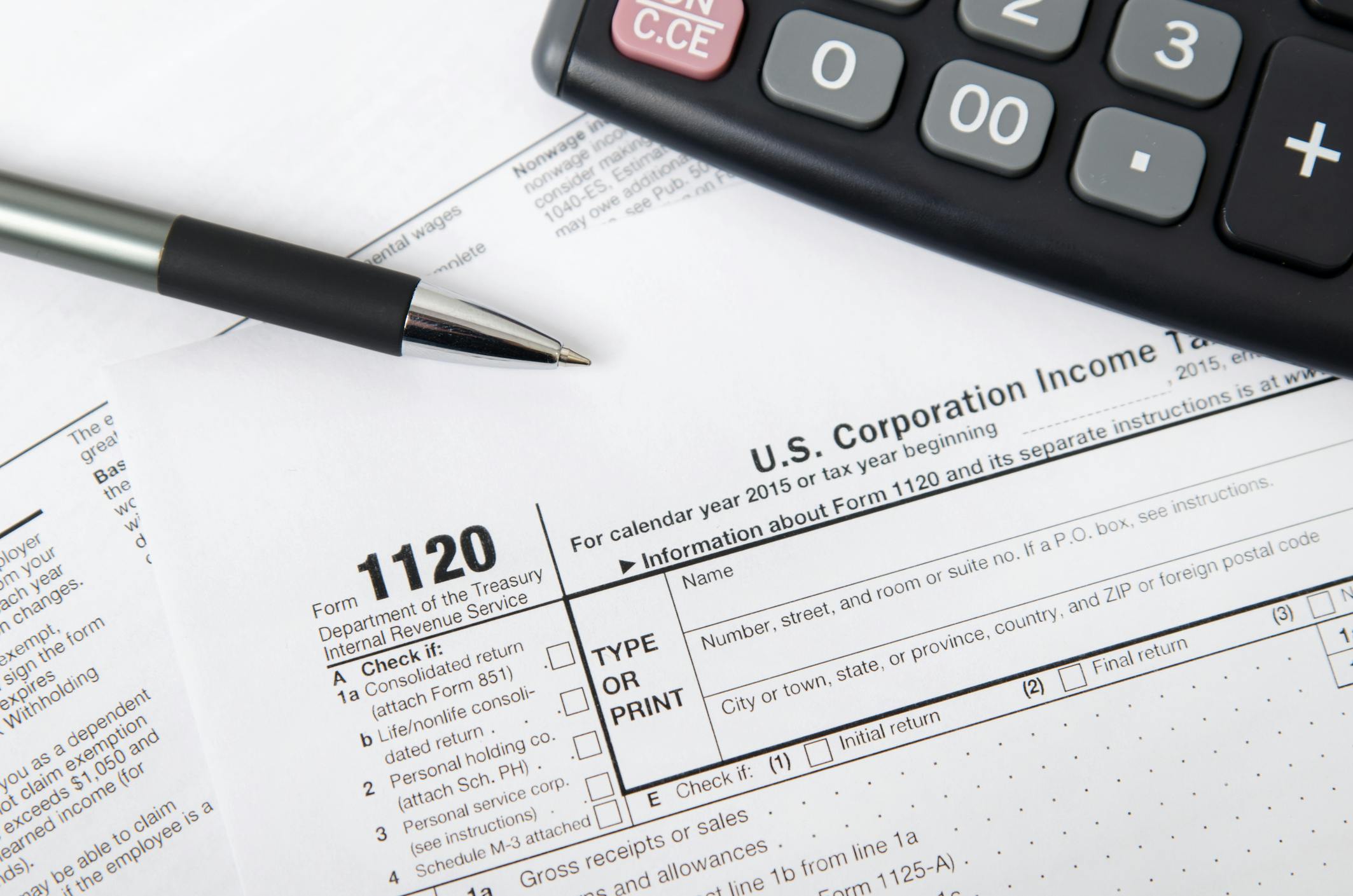 U.S. corporate tax forms, calculator and pen
