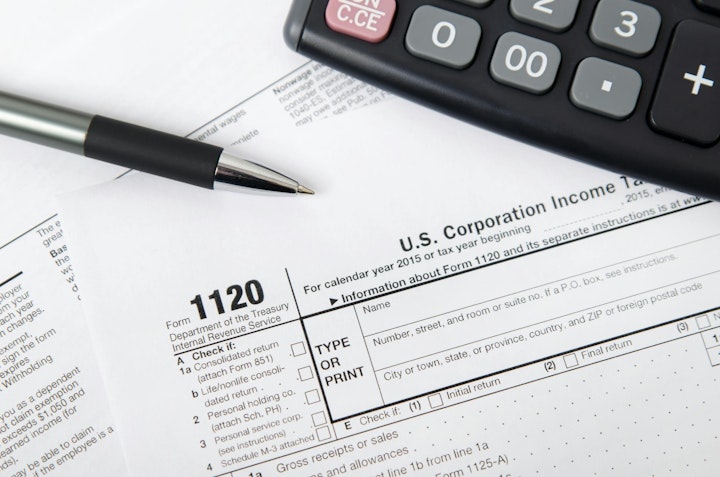 U.S. corporate tax forms, calculator and pen