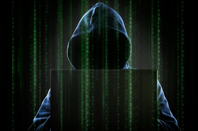 A hooded hacker at a computer.