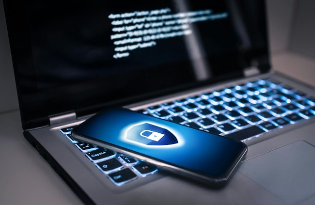 A locked phone sits on a laptop computer.