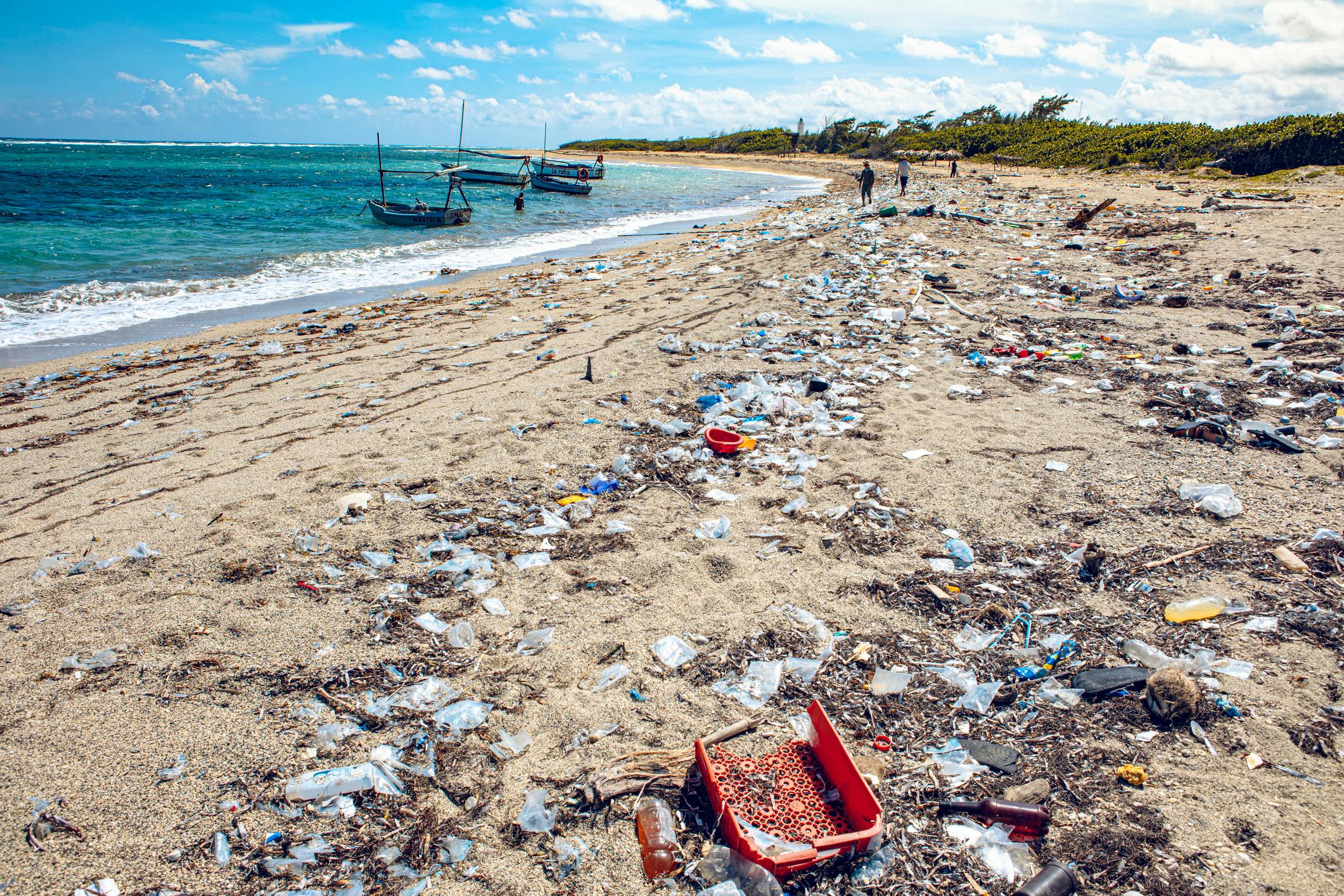 Plastic trash litters an ocean beach.