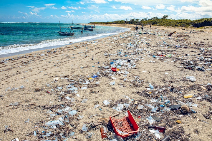 Plastic trash litters an ocean beach.