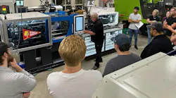 John Wiley, director of customer service for LS Mtron, tells the advanced injection molding class at Ferris State University about the consigned One 55E injection molding machine they will be using.