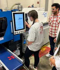 A Pittsburg State University molding student studies the control panel of a consigned LS Mtron One 55E injection molding machine.