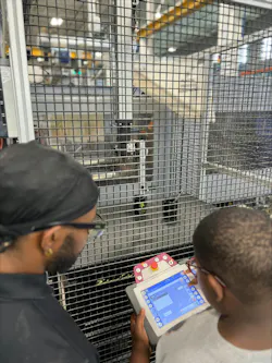 Molding Kids for Success program participants learn injection molding basics including how to operate a digital controller. Anthony Oliver, left, supervises a student’s lesson.
