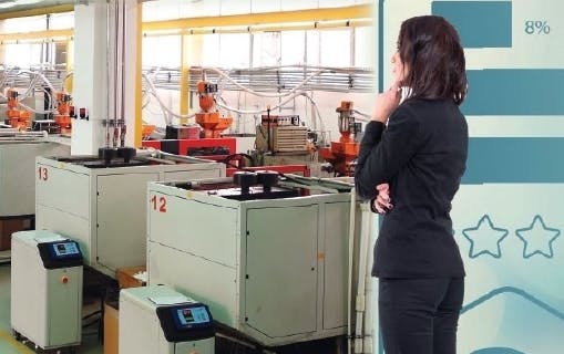 A businesswoman thinking about investments as she looks at plastics equipment.
