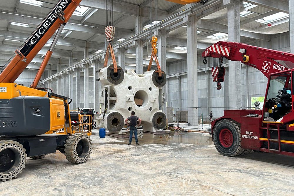 Trucks and cranes were needed to unload components of a supersized Haitian injection molding machine.