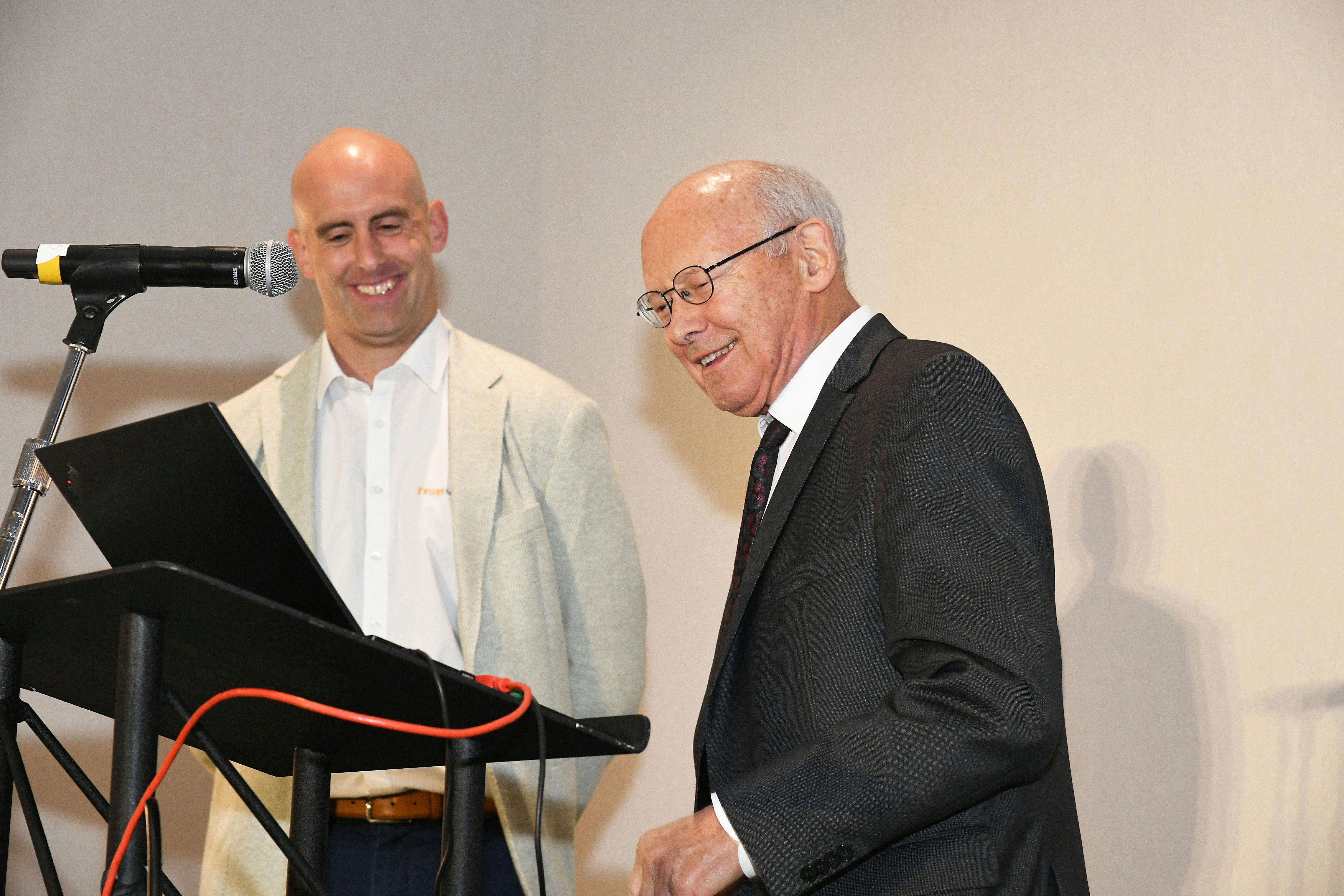 Harald Feuerherm (right) steps to the microphone to accept the Lifetime Achievement Award after an introduction by his grandson, Max.