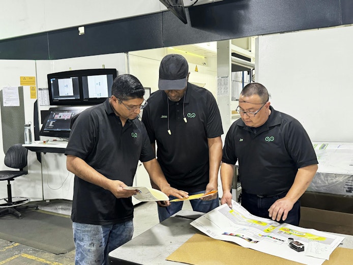 Employees look over materials regarding color matching at Union City, Calif., converter Emerald Packaging.