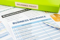 Business insurance paperwork and green binder. Business insurance paperwork and green binder.
