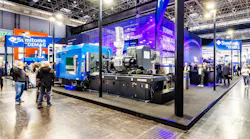 K show visitors walk past Sumitomo (SHI) Demag's booth.
