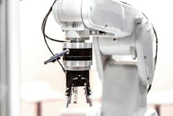 A white industrial robot arm with a gripper end-of-arm tool A white industrial robot arm with a gripper end-of-arm tool