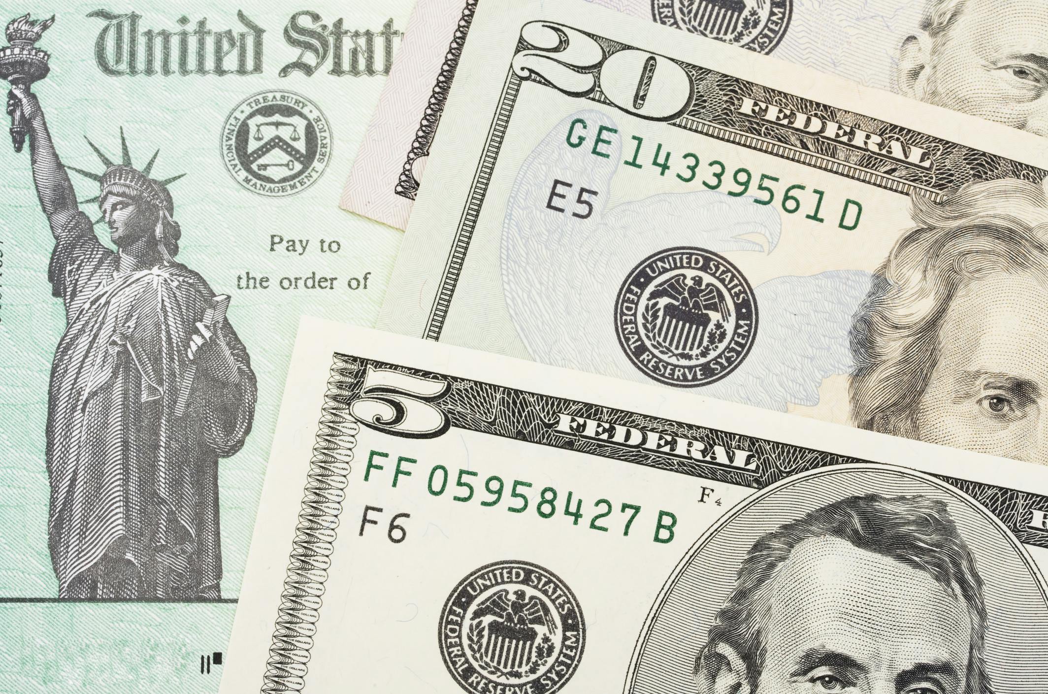 U.S. Treasury check with $5 and $20 bills overlaid