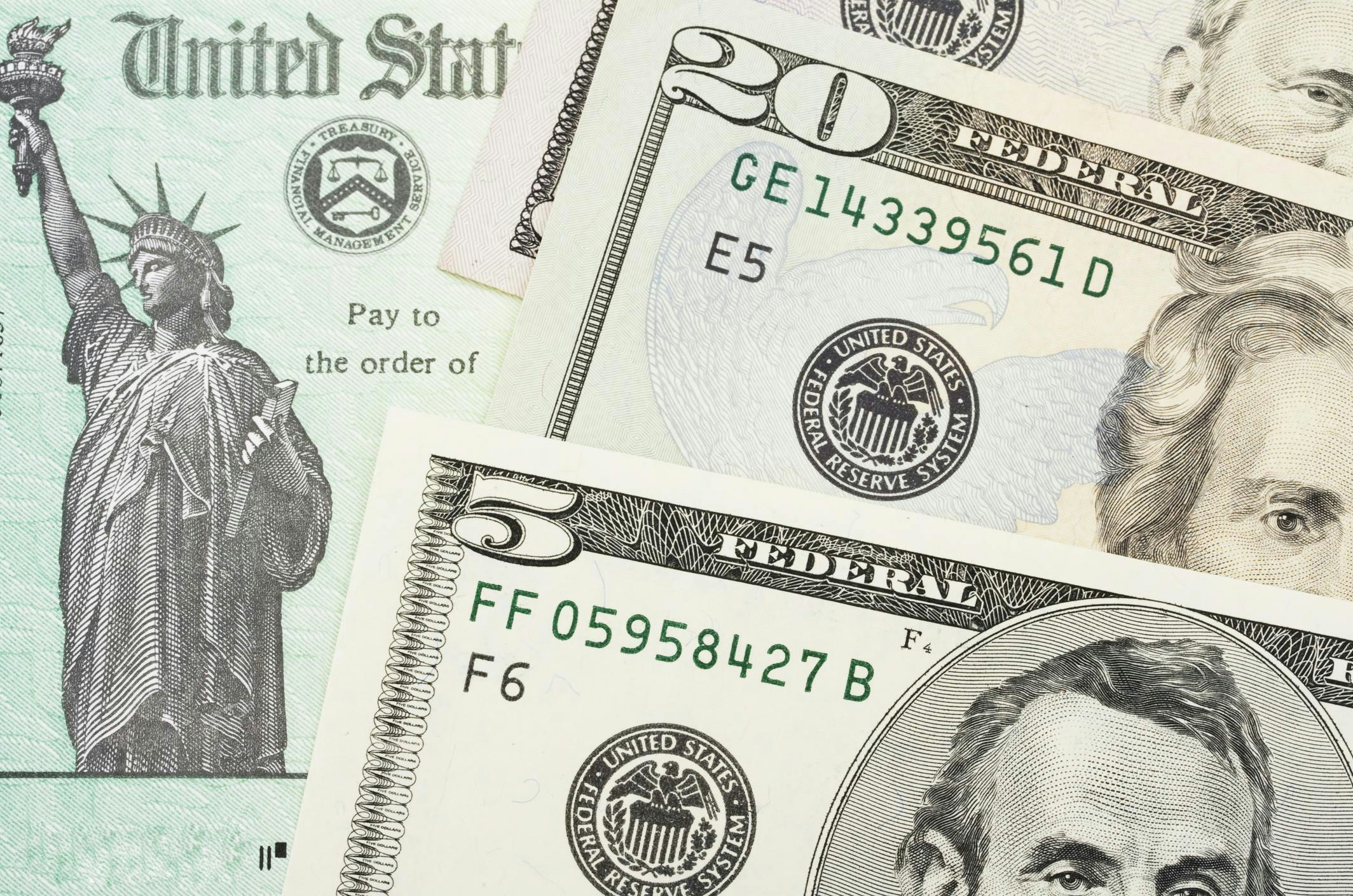 U.S. Treasury check with $5 and $20 bills overlaid