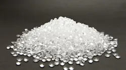 Clear high density polyethylene resin pellets on gray background Clear high density polyethylene resin pellets on gray background