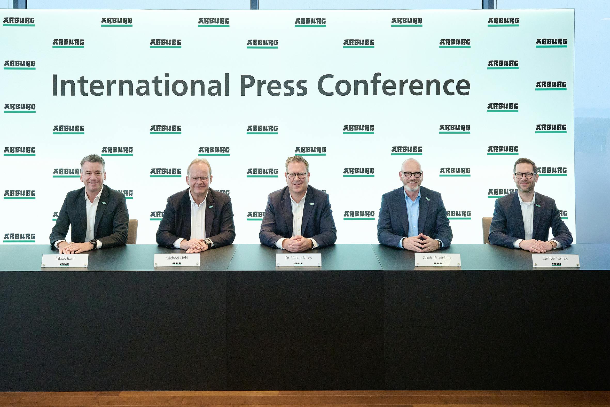 Five Arburg executives at a table for a press conference at Technology Days.