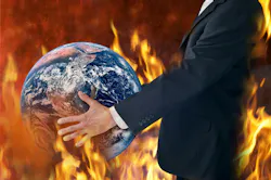 Businessman holds a globe as fires burn around him Businessman holds a globe as fires burn around him