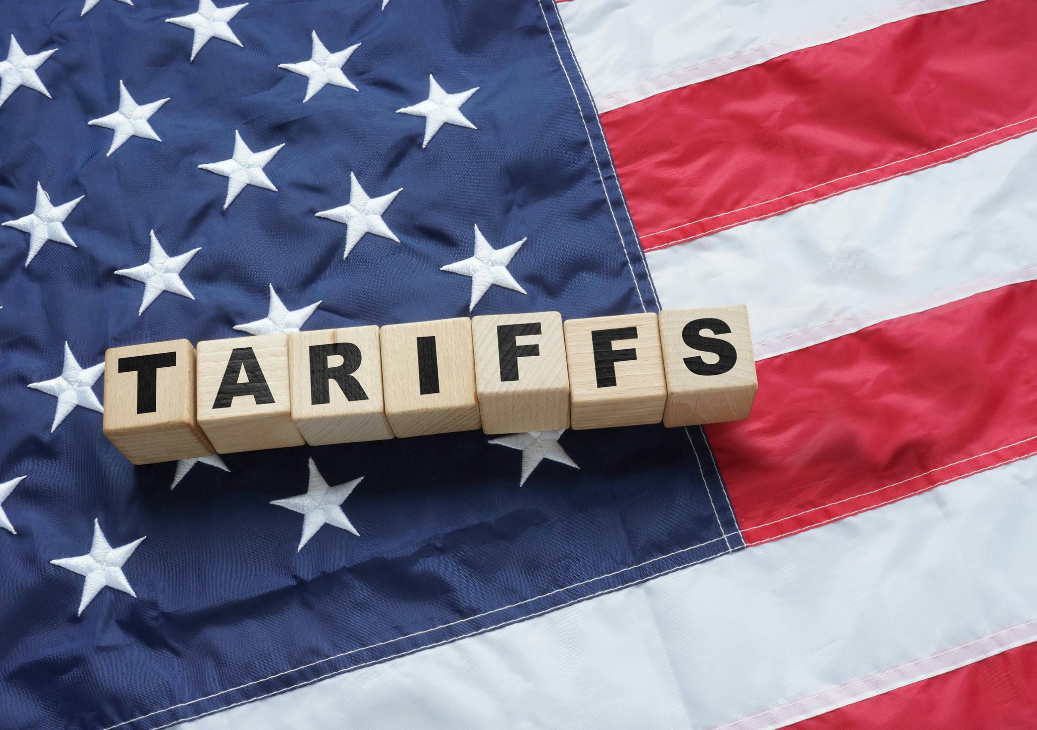 An American flag overlaid with the word 'tariffs.'