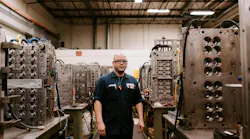 A Hoffer Plastics worker surrounded by injection molds. A Hoffer Plastics worker surrounded by injection molds.