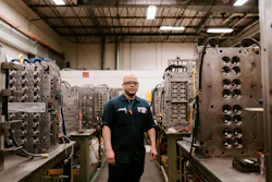 A Hoffer Plastics worker surrounded by injection molds. A Hoffer Plastics worker surrounded by injection molds.
