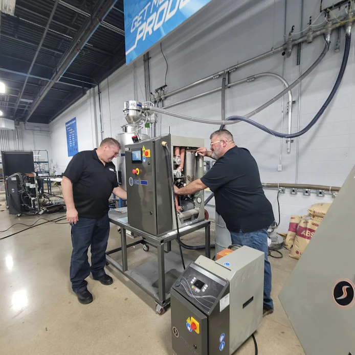 ACS technicians work on a machine. By prioritizing preventive and predictive maintenance, manufacturers can reduce unplanned downtime.