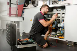 A technician crouches beside Wittmann equipment. Like other OEMs, Wittmann is working to make its machines easier to use, with tools that will help processors better spot trends that could indicate future maintenance needs. A technician crouches beside Wittmann equipment. Like other OEMs, Wittmann is working to make its machines easier to use, with tools that will help processors better spot trends that could indicate future maintenance needs.