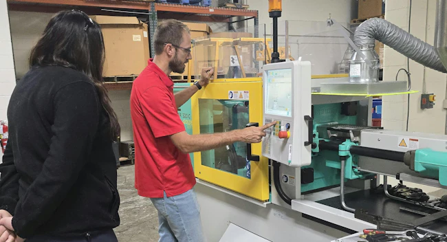 Tom Van Pernis of Ferris State University&rsquo;s plastics engineering technology program at an injection molding machine.