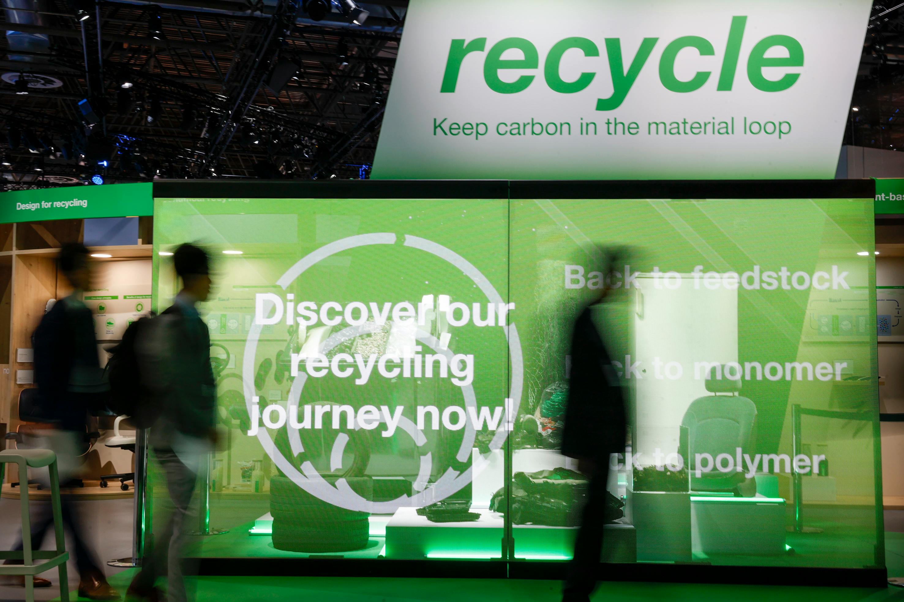 Green and white signage touting plastics recycling.
