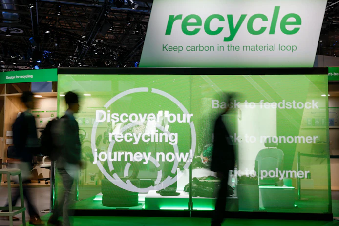 Green and white signage touting plastics recycling.