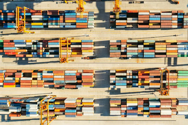 Rows of shipping containers in a port, viewed from above.