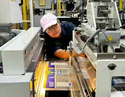 An employee at Emerald Packaging sets up a Hudson-Sharp Inno-Lok hermetic zipper machine. An employee at Emerald Packaging sets up a Hudson-Sharp Inno-Lok hermetic zipper machine.