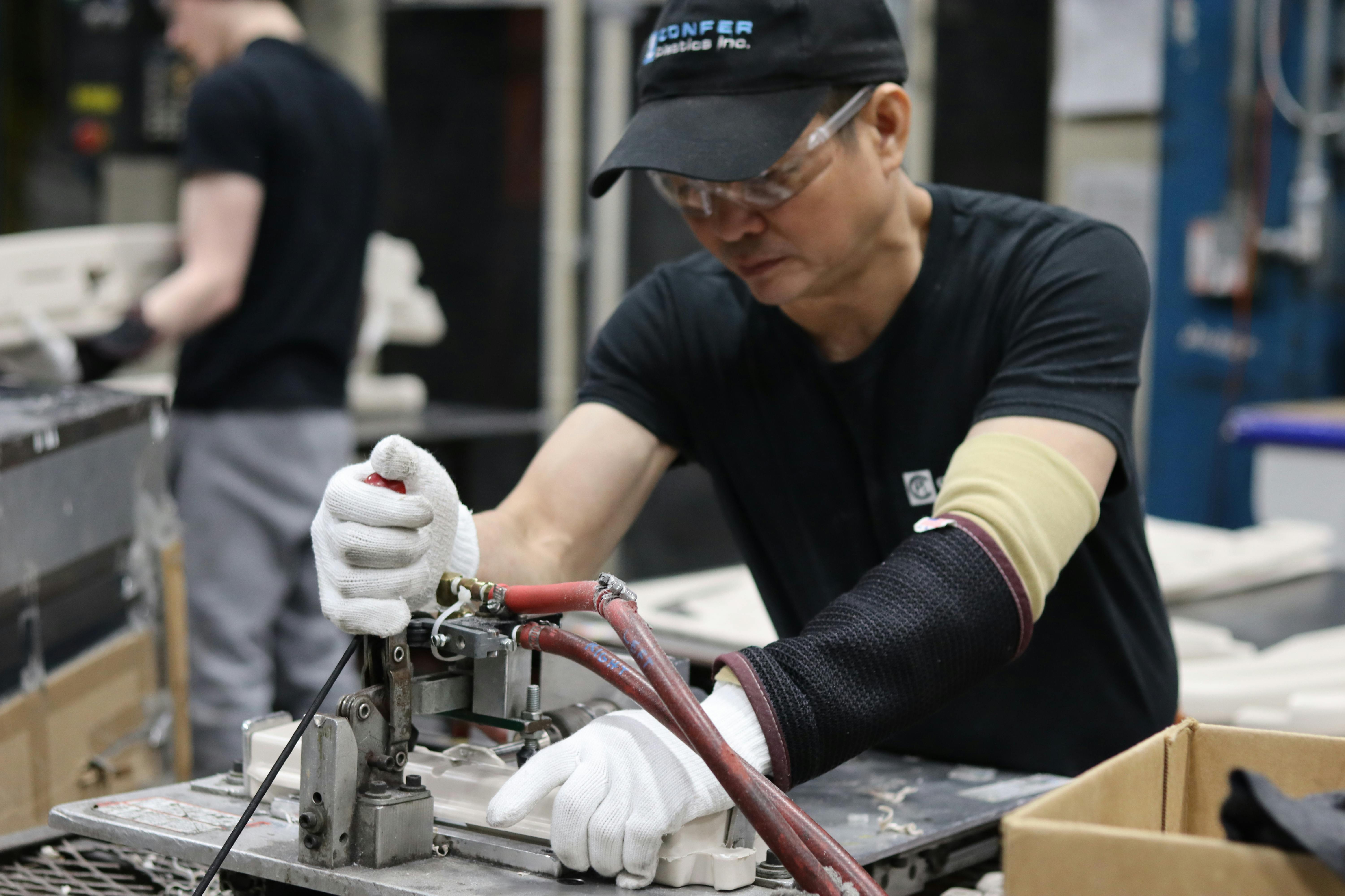 Tien Nguyen, from Vietnam, works on a swimming-pool ladder part at Confer Plastics.