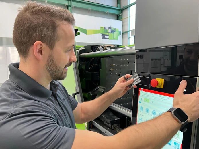 An Engel technician works on an injection molding machine.