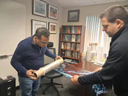 Zahidul Wahab (left), a research fellow at Peak Nano, and Michael Ponting, the company’s chief science officer, display a film made by the company to block ultraviolet light.
