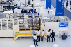 A group of people watch a part being produced on a Haitian injection molding machine. A group of people watch a part being produced on a Haitian injection molding machine.