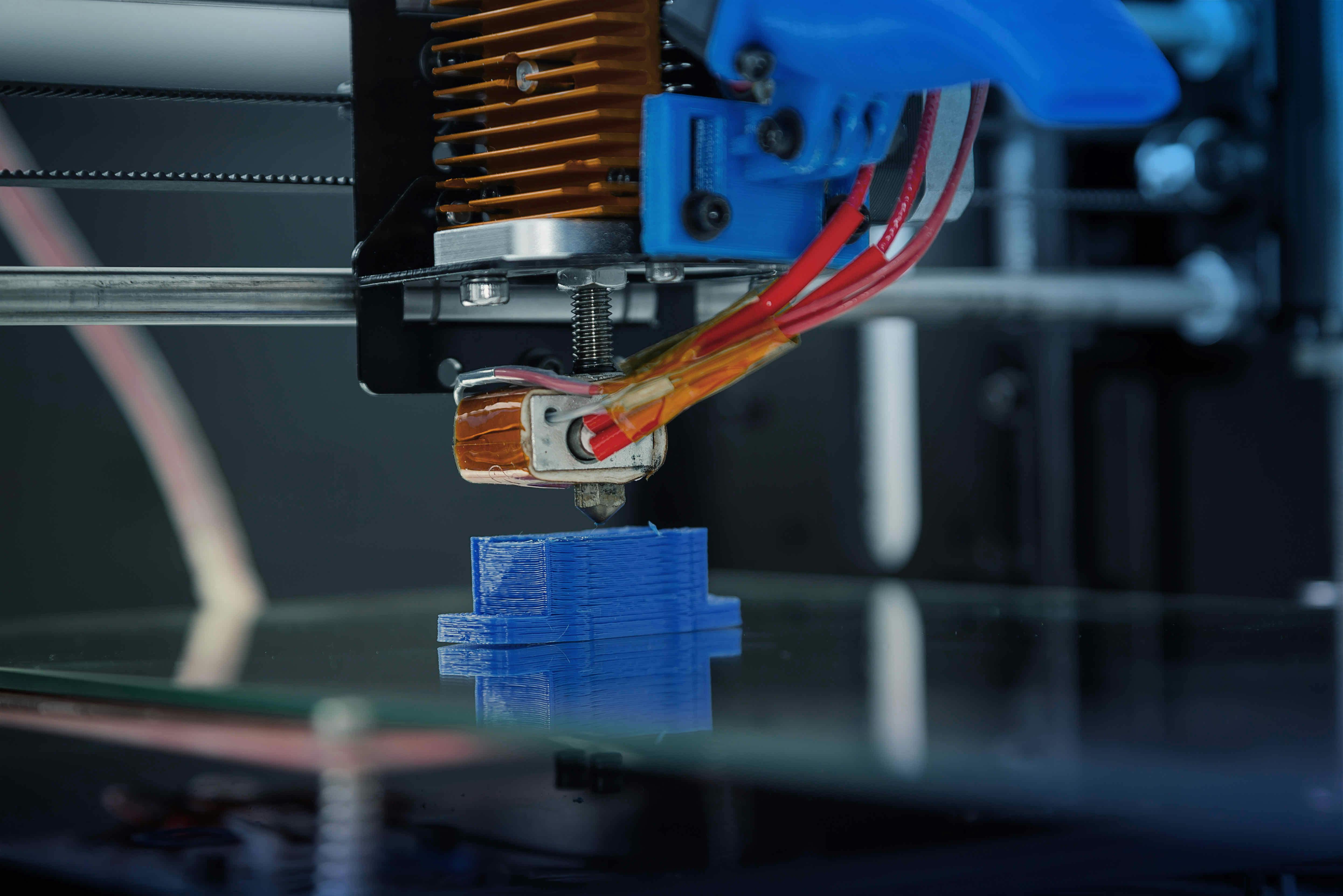 Machine producing a blue plastic part.