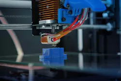 Machine producing a blue plastic part.