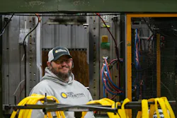 A worker at a blow molding machine at Agri-Industrial Plastics