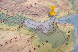 A map depicts the Strait of Hormuz with a yellow pin
