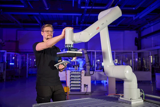 Man reaches out to touch a PoWa cobot