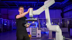 Man reaches out to touch a PoWa cobot