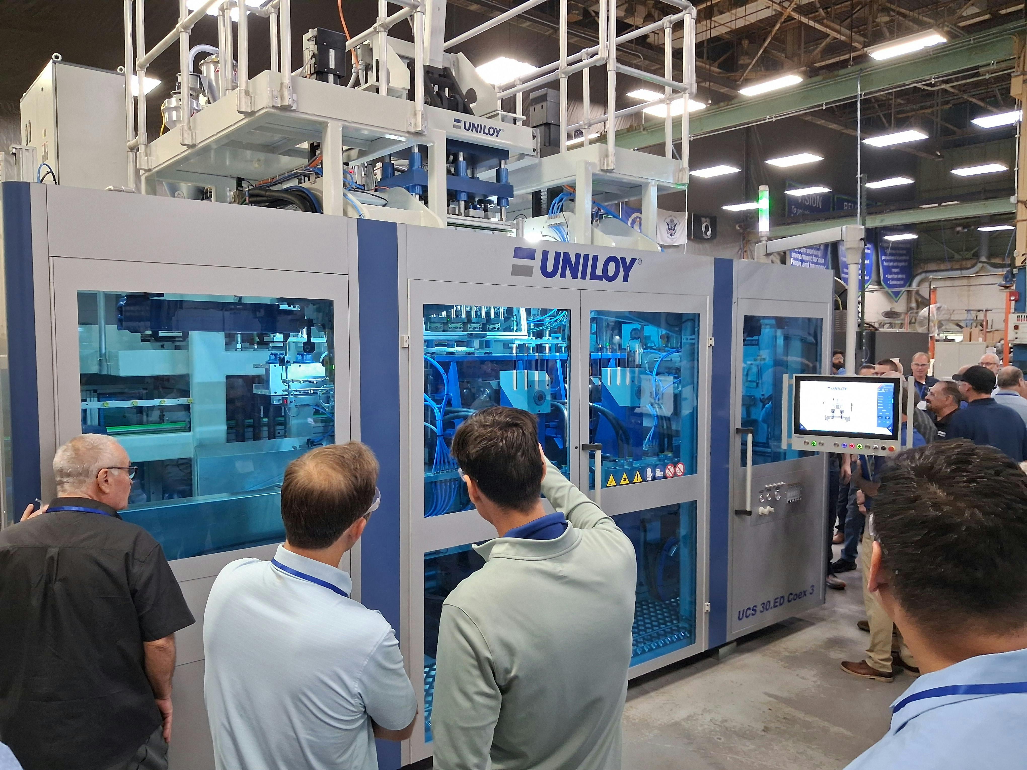 Attendees at Uniloy's July 23 open house watch a UCS 30.ED blow molding machine in operation.