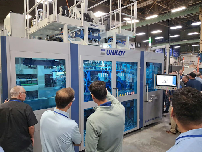 Attendees at Uniloy's July 23 open house watch a UCS 30.ED blow molding machine in operation.