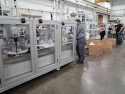 A Uniloy UR 100 12-cavity reciprocating machine produces bottles during the company's open house.